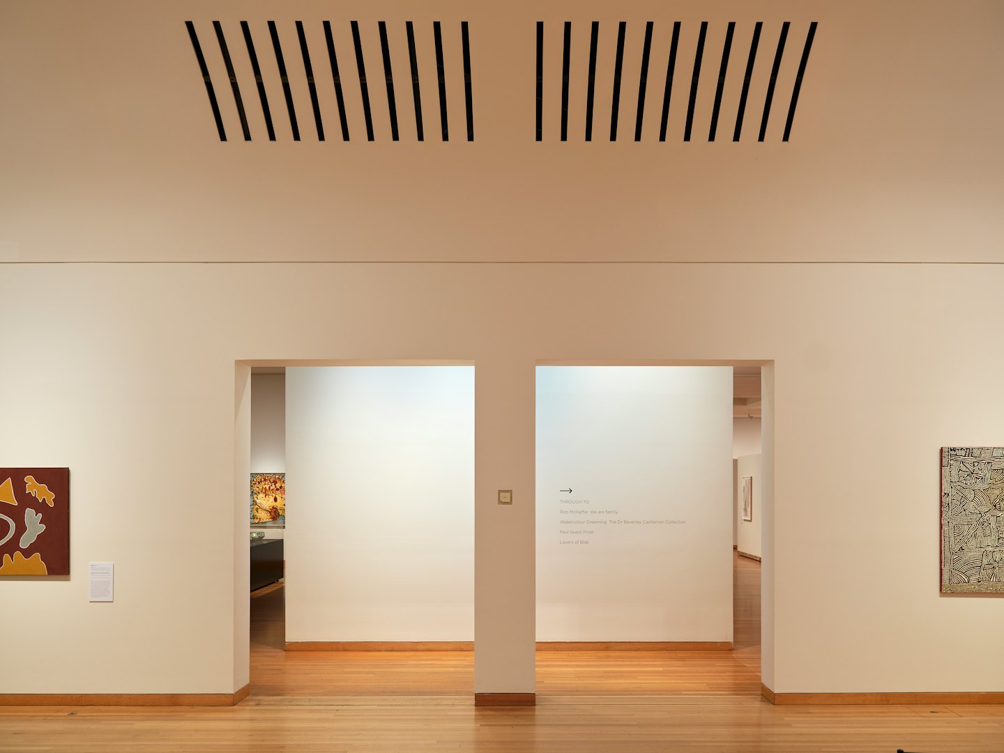 Minimalist art gallery with white walls and archways.